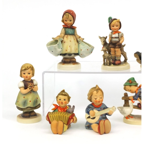 2096 - Group of nine Goebel Hummel figures including a boy with a trumpet and a boy with a duck, the larges... 