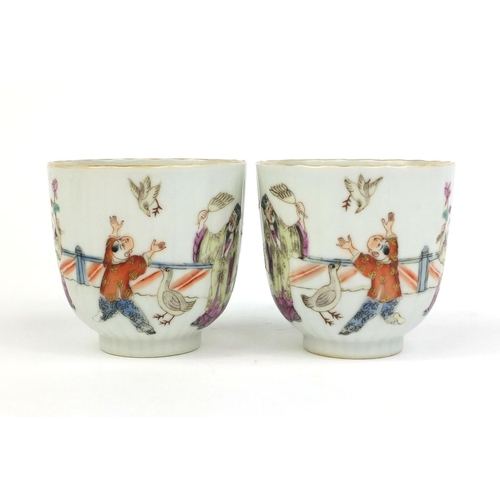364 - Pair of Chinese porcelain tea cups painted in the famille rose palette with court figures playing, f... 