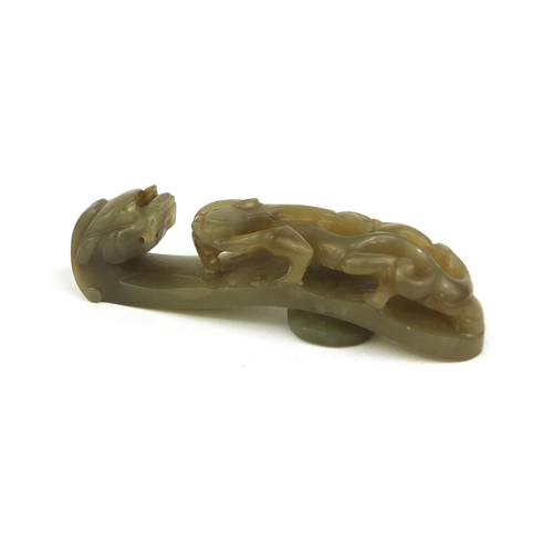 438 - Chinese green jade belt hook carved with a dragon, 8cm in length