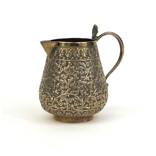 512 - Persian silver jug with serpent handle, profusely embossed with flowers and foliage, 10cm high, appr... 