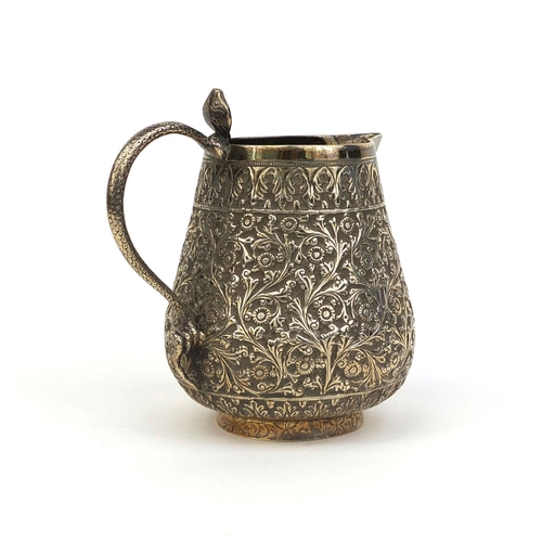 512 - Persian silver jug with serpent handle, profusely embossed with flowers and foliage, 10cm high, appr... 