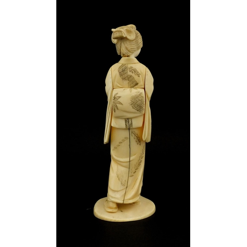 461 - Japanese carved ivory okimono of a girl holding a comb, red inset character marks to the base, 17cm ... 