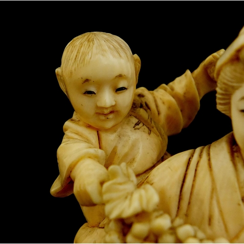 457 - Japanese carved ivory okimono of a mother holding her baby and grapes, character marks to the base, ... 