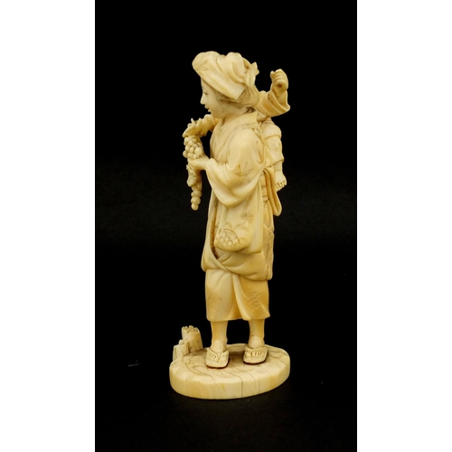 457 - Japanese carved ivory okimono of a mother holding her baby and grapes, character marks to the base, ... 