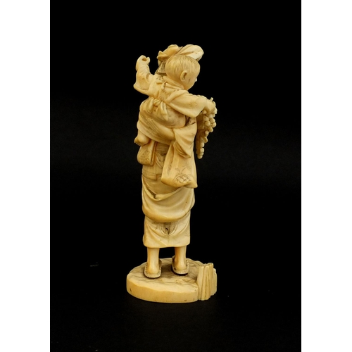 457 - Japanese carved ivory okimono of a mother holding her baby and grapes, character marks to the base, ... 