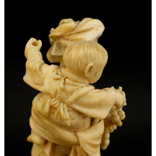 457 - Japanese carved ivory okimono of a mother holding her baby and grapes, character marks to the base, ... 