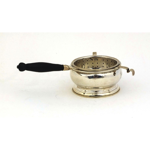 697 - Silver tea strainer with ebonised wooden handle and a matched silver stand,  hallmarked Birmingham 1... 