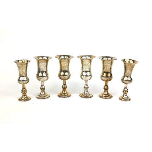 689 - Set of four silver aperitif cups with engraved decoration, together with a pair of similar examples,... 