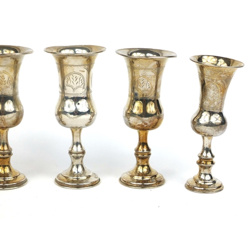 689 - Set of four silver aperitif cups with engraved decoration, together with a pair of similar examples,... 