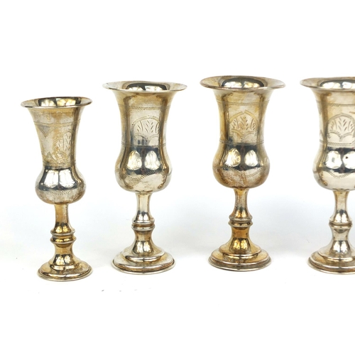 689 - Set of four silver aperitif cups with engraved decoration, together with a pair of similar examples,... 