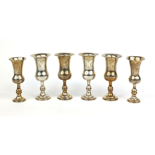 689 - Set of four silver aperitif cups with engraved decoration, together with a pair of similar examples,... 