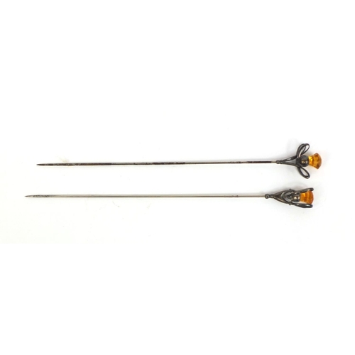 643 - Two Art Nouveau silver hat pins, one by Charles Horner, each set with a thistle shaped citrine, the ... 