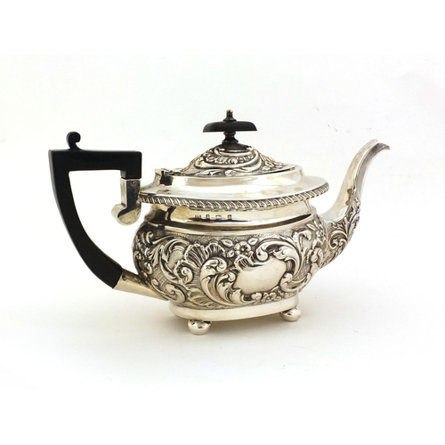 682 - Silver teapot, profusely embossed floral decoration and blank cartouche, with ebonised wooden handle... 