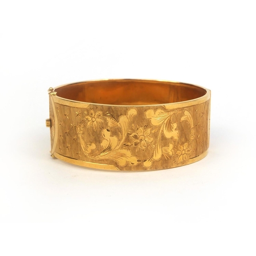 775 - 18ct gold bangle finely engraved with flowers and stars, impressed marks 750 and 238VI to the clasp,... 