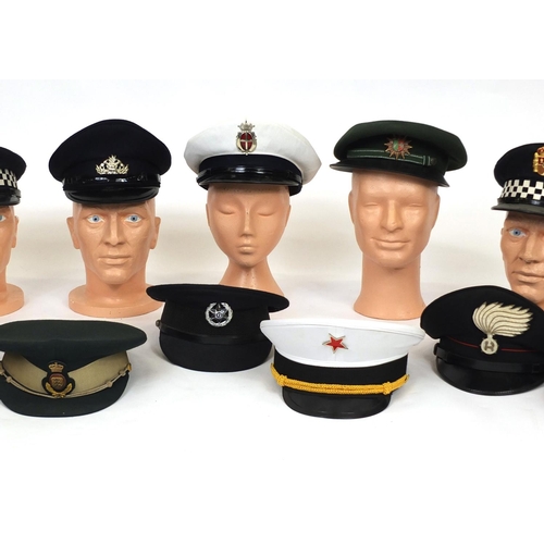 349 - Group of twelve police and fire caps, various countries some with badges, some with labels to the in... 