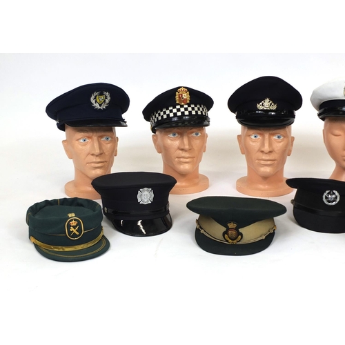 349 - Group of twelve police and fire caps, various countries some with badges, some with labels to the in... 