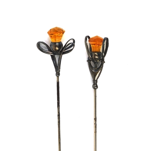 643 - Two Art Nouveau silver hat pins, one by Charles Horner, each set with a thistle shaped citrine, the ... 