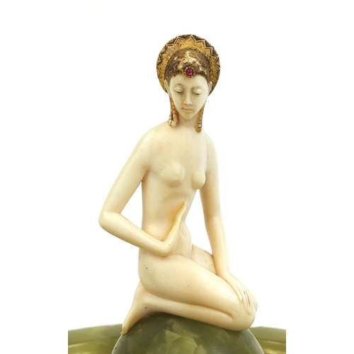 630 - Art Deco carved ivory maiden sat on a green onyx centre piece, the nude maiden wearing a headdress w... 