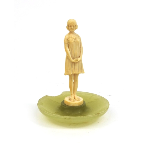 632 - Art Deco carved ivory figure of a young girl wearing a dress, raised on a circular onyx base, inscri... 