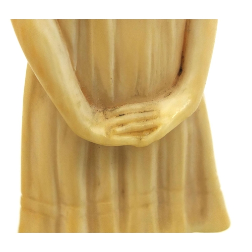 632 - Art Deco carved ivory figure of a young girl wearing a dress, raised on a circular onyx base, inscri... 