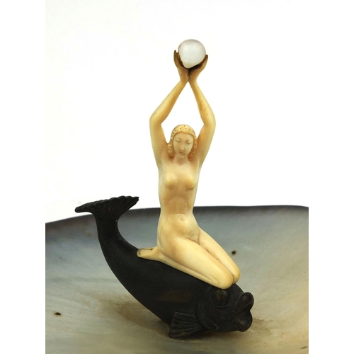631 - Art Deco carved ivory figure of a nude female sat upon a stylised fish, raised a three footed Mother... 