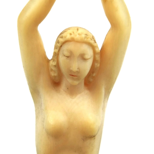 631 - Art Deco carved ivory figure of a nude female sat upon a stylised fish, raised a three footed Mother... 
