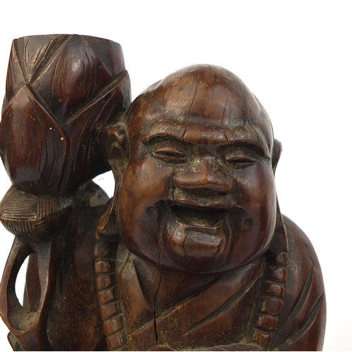 477 - Pair of Chinese root carved lamp bases, each of a Buddha holding a nut, each 37cm high