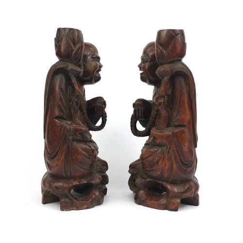 477 - Pair of Chinese root carved lamp bases, each of a Buddha holding a nut, each 37cm high