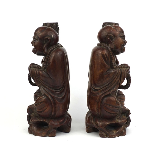 477 - Pair of Chinese root carved lamp bases, each of a Buddha holding a nut, each 37cm high