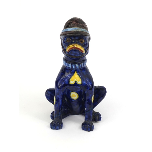 616 - Mosanic faience glazed pottery cat seated wearing a policeman's helmet, hand painted with hearts and... 