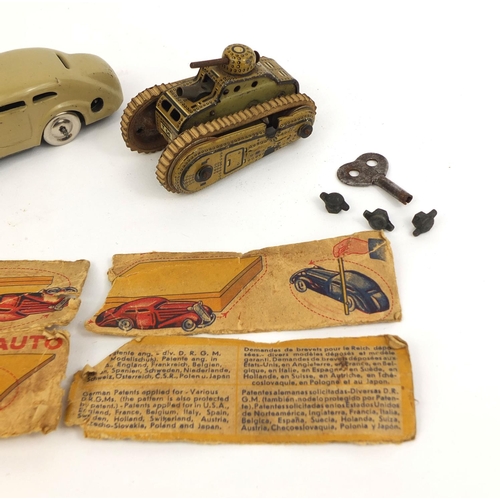 252 - Boxed Schuco tinplate model car together with a tinplate clockwork tank, the largest 11cm in length