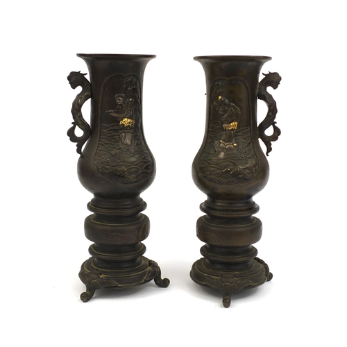 472 - Pair of Japanese bronze twin handled vases, with animalia handles, each decorated in silver with fig... 