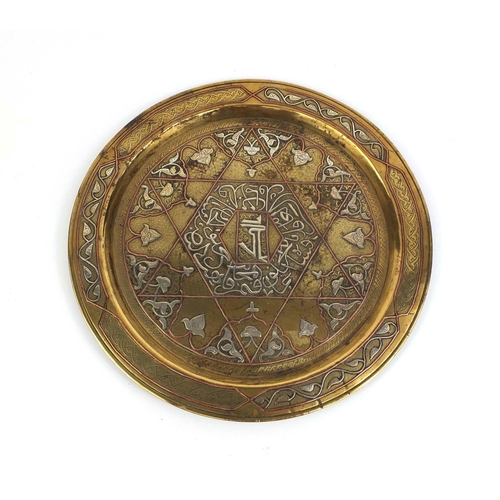 519 - Egyptian Cairo ware brass tray decorated with silver and copper script, 35cm in diameter