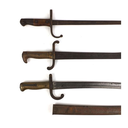 308 - Group of three Military interest bayonets including one with scabbard and one with wooden grip, each... 