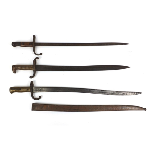 308 - Group of three Military interest bayonets including one with scabbard and one with wooden grip, each... 