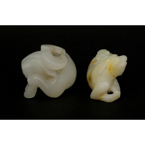 439 - Two Chinese pale jade carvings comprising one of a buffalo biting a branch and one of a dog a foo re... 