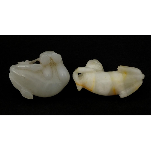 439 - Two Chinese pale jade carvings comprising one of a buffalo biting a branch and one of a dog a foo re... 