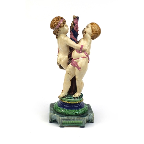 531 - Victorian Minton Majolica pottery candlestick modelled as a pair of  dancing putti with pink ribbons... 