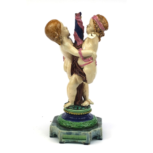 531 - Victorian Minton Majolica pottery candlestick modelled as a pair of  dancing putti with pink ribbons... 