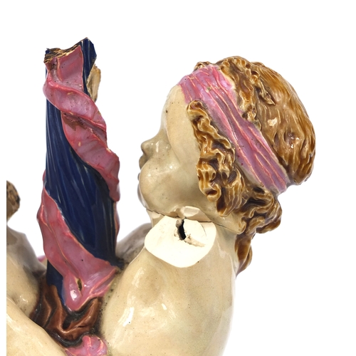 531 - Victorian Minton Majolica pottery candlestick modelled as a pair of  dancing putti with pink ribbons... 