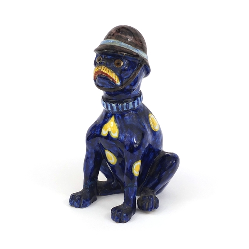 616 - Mosanic faience glazed pottery cat seated wearing a policeman's helmet, hand painted with hearts and... 