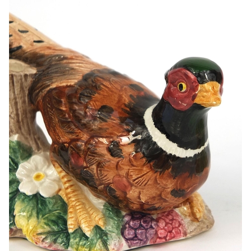 2107 - Pair of hand painted pheasant design candle holders, the largest 15cm high