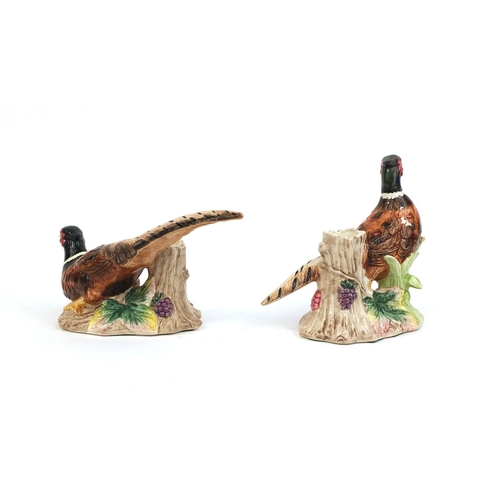 2107 - Pair of hand painted pheasant design candle holders, the largest 15cm high