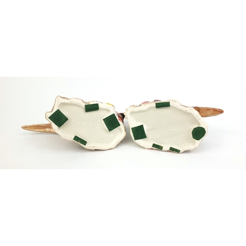 2107 - Pair of hand painted pheasant design candle holders, the largest 15cm high