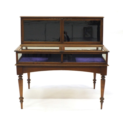 2005 - Victorian stained pine glazed museum cabinet with four lift up glazed doors raised on turned legs, 1... 
