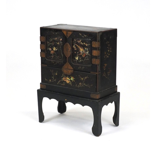 2021 - Oriental lacquered cabinet on stand, pair of doors enclosing six pull out drawers above a large pull... 