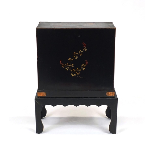 2021 - Oriental lacquered cabinet on stand, pair of doors enclosing six pull out drawers above a large pull... 