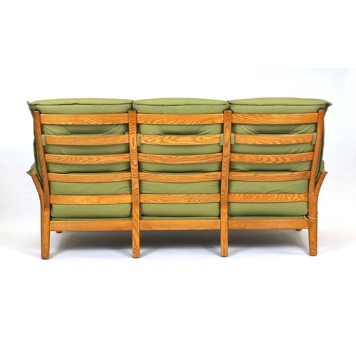 2009 - Ercol elm green leather upholstered seat comprising a three seater settee and two open armchairs, ea... 