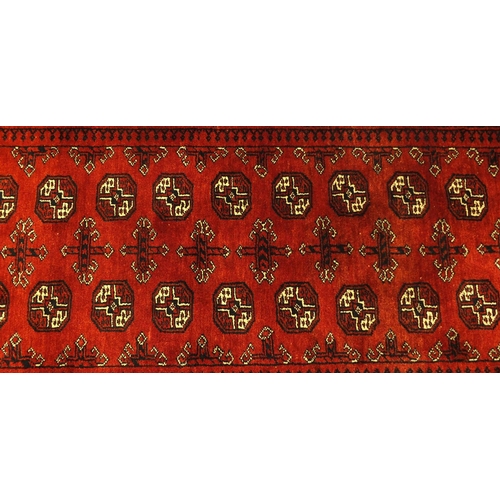 2034 - Rectangular Afghan rug, having a repeat tribal gul design, within geometric boarders onto a red grou... 