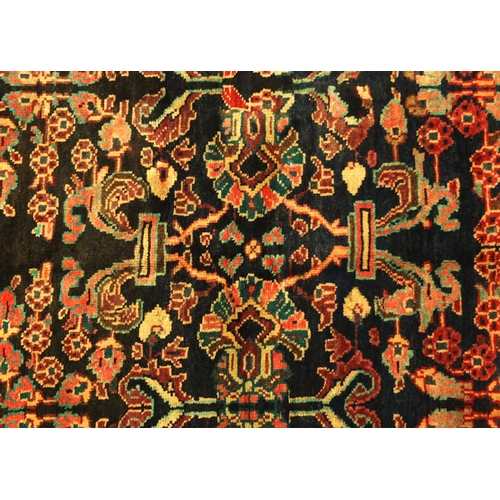 2024 - Rectangular Persian Mahal rug, the centeral field decorated with stylised motifs within foliate boar... 